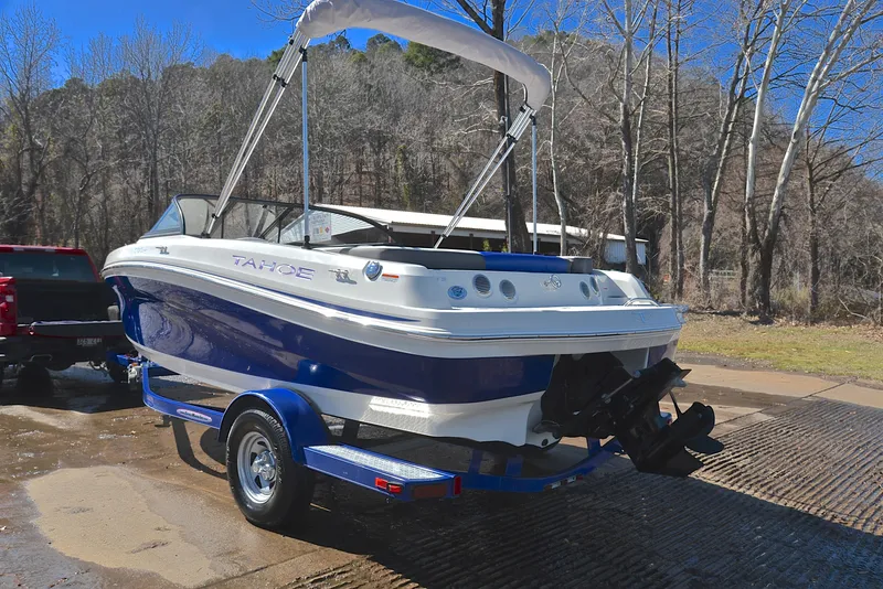 Slide: The Image of 2015 Tahoe 500 TS boat on trailer, parked outdoors near trees. - 10
