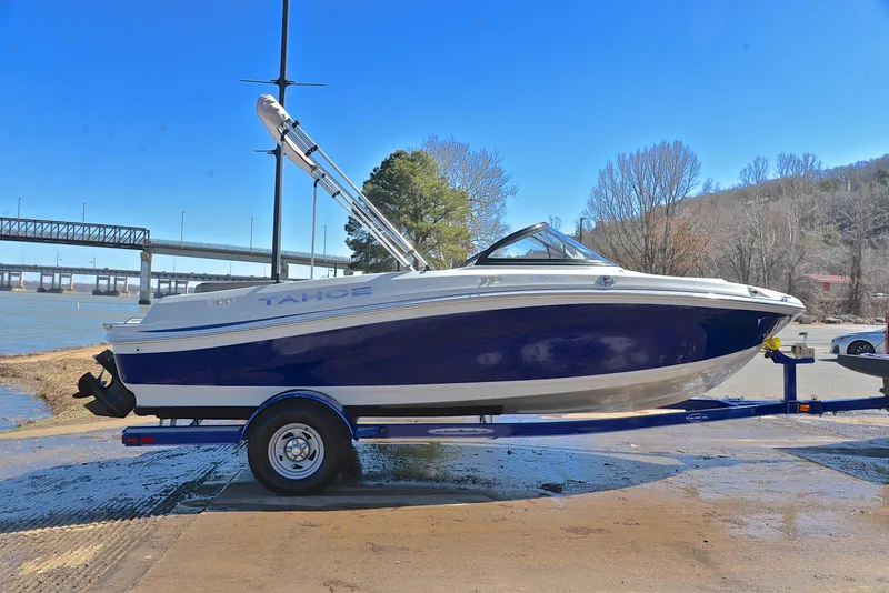 Slide: The Image of 2015 Tahoe 500 TS boat on trailer by riverside, clear blue sky background. - 13