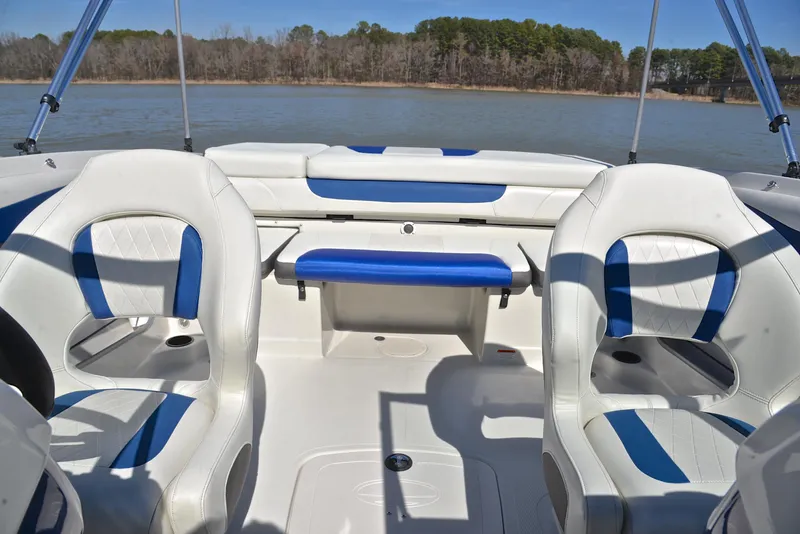 Slide: The Image of 2015 Tahoe 500 TS boat interior with white and blue seating on a lake. - 20