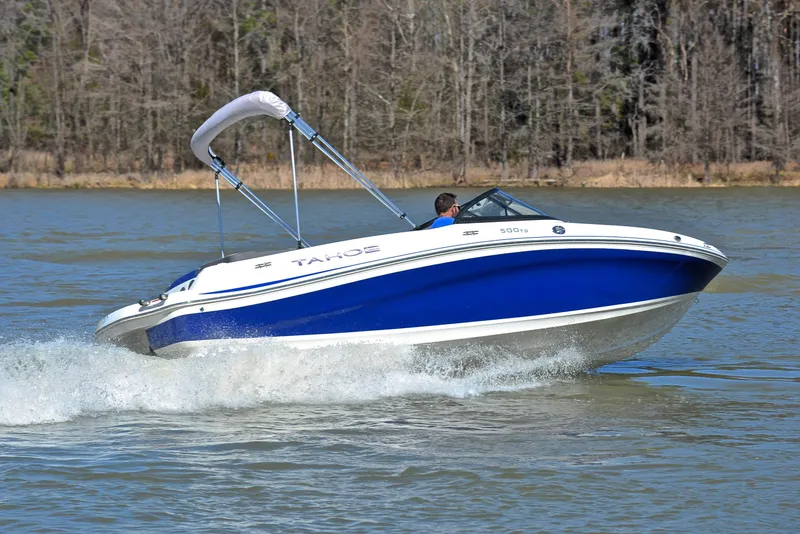Slide: The Image of 2015 Tahoe 500 TS boat cruising on a lake with forested background. - 26