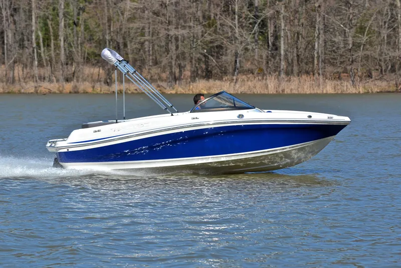 Slide: The Image of 2015 Tahoe 500 TS boat cruising on a lake with forested background. - 3