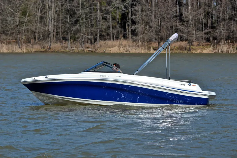 Slide: The Image of 2015 Tahoe 500 TS boat cruising on a lake with forested background. - 7