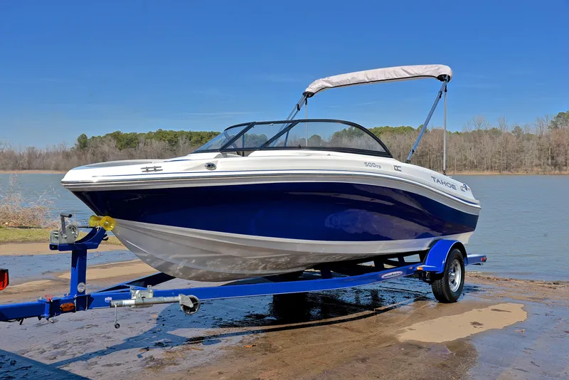 Slide: The Image of 2015 Tahoe 500 TS boat on trailer by a lake under clear blue sky. - 8