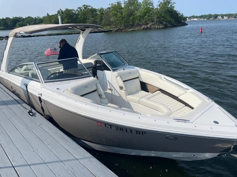 Slide: The Image of 2018 Cobalt R7 boat docked on a lake with lush greenery. - 2