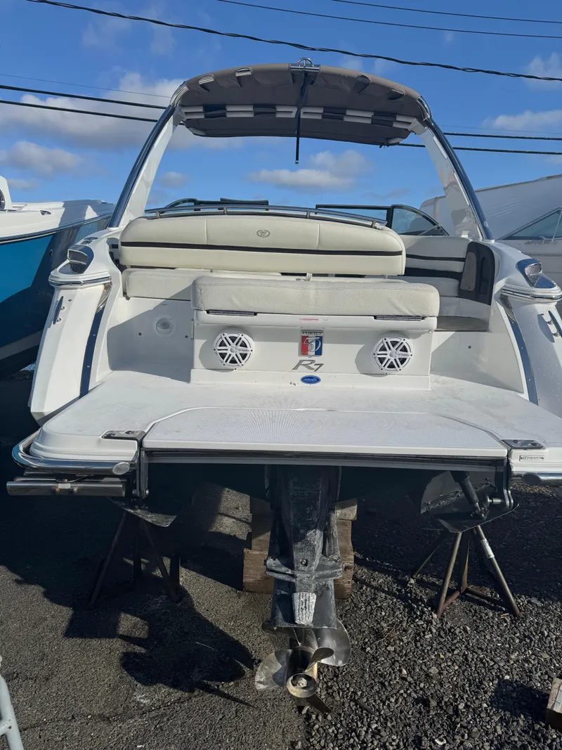 Slide: The Image of 2018 Cobalt R7 boat, rear view, showcasing swim platform and seating under clear blue sky. - 7