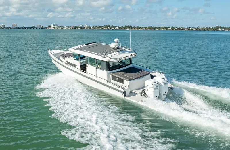 Slide: The Image of 2017 Axopar 37 XC Cross Cabin cruising on open water, showcasing sleek design and powerful engines. - 3