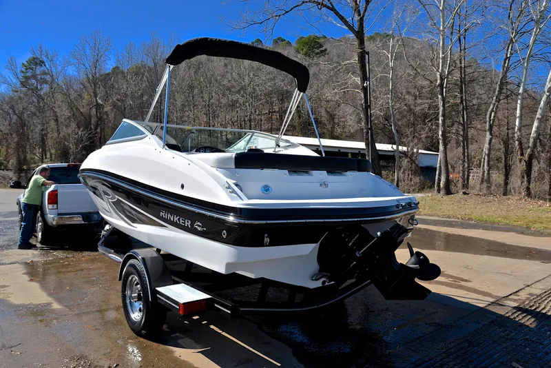 Slide: The Image of 2014 Rinker 196 Captiva boat on trailer, parked outdoors near trees. - 12