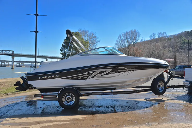 Slide: The Image of 2014 Rinker 196 Captiva boat on trailer by a river, clear blue sky. - 15