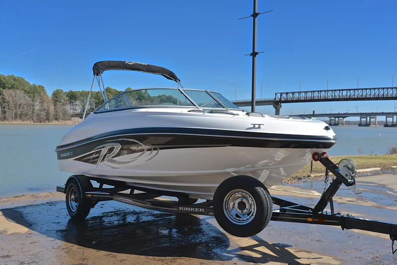 Slide: The Image of 2014 Rinker 196 Captiva boat on trailer by a river, clear blue sky. - 16
