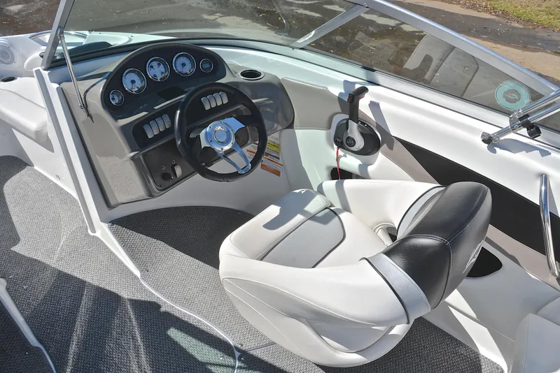 Slide: The Image of Interior of a 2014 Rinker 196 Captiva boat, featuring steering wheel and dashboard. - 24