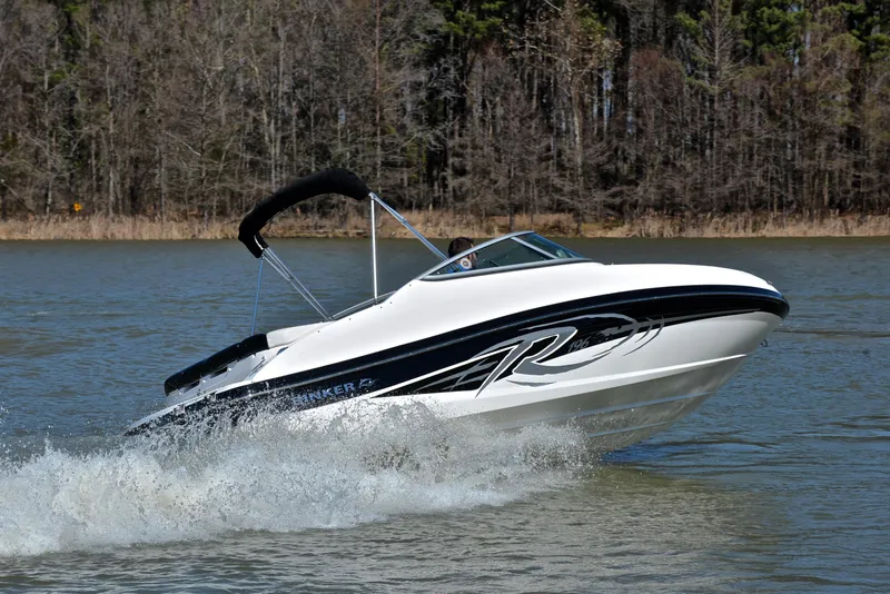 Slide: The Image of 2014 Rinker 196 Captiva speedboat cruising on a lake with forested background. - 5