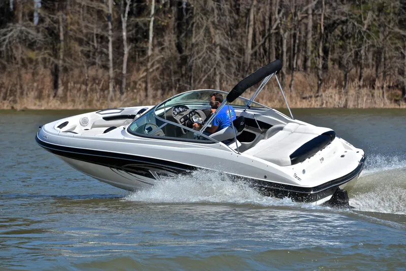 Slide: The Image of 2014 Rinker 196 Captiva speedboat cruising on a lake with trees in the background. - 6