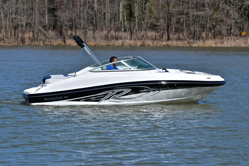 Slide: The Image of 2014 Rinker 196 Captiva boat cruising on a lake with forested shoreline. - 7