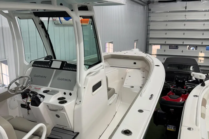 Slide: The Image of 2019 Everglades 273 Center Console boat in a garage, featuring Garmin navigation systems. - 4