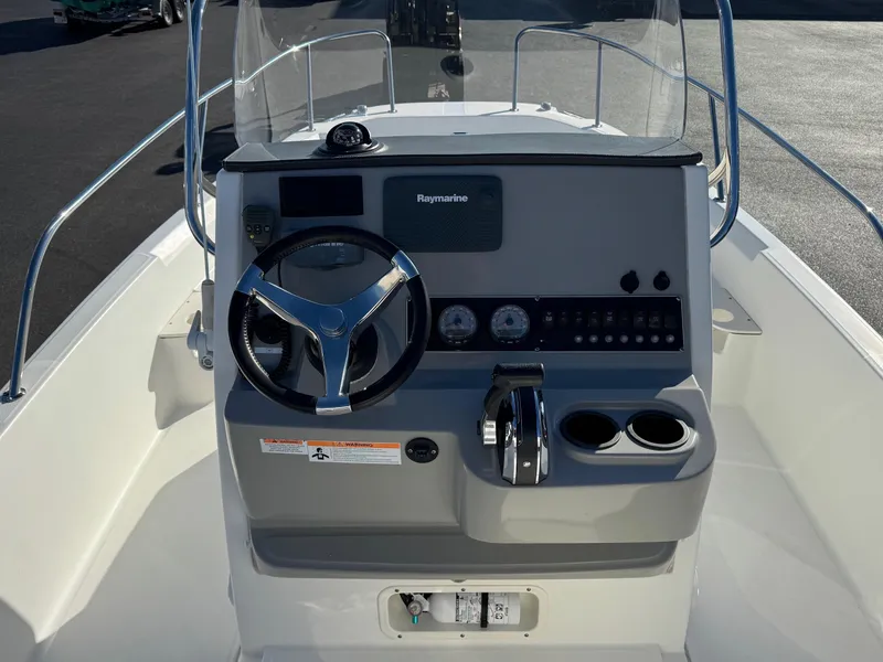 Slide: The Image of 2014 Boston Whaler 210 Dauntless boat console with steering wheel and controls. - 12