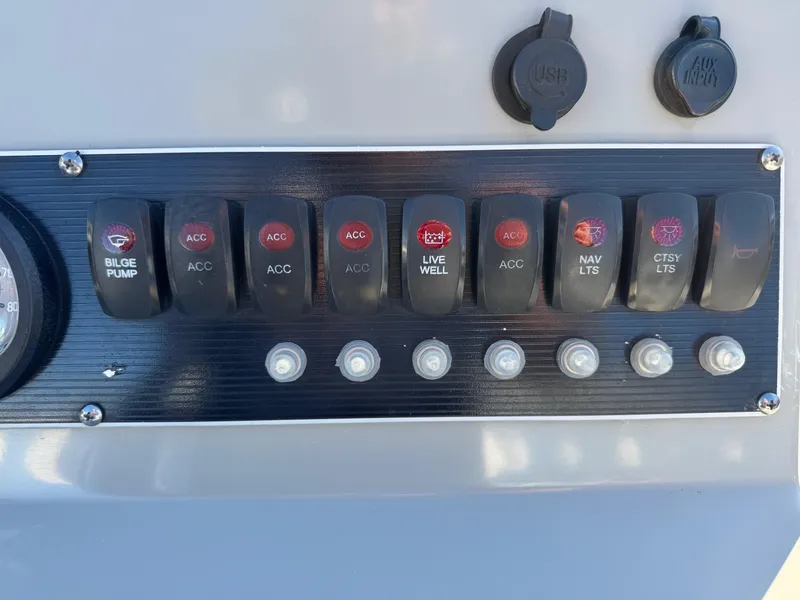 Slide: The Image of Control panel of a 2014 Boston Whaler 210 Dauntless boat with labeled switches. - 20