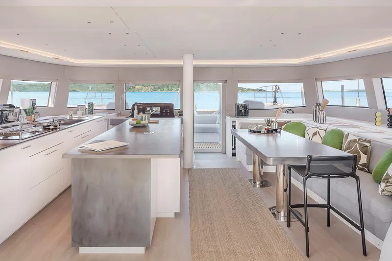 Slide: The Image of Luxurious interior of 2025 Lagoon SIXTY 5 catamaran with modern kitchen and dining area. - 11