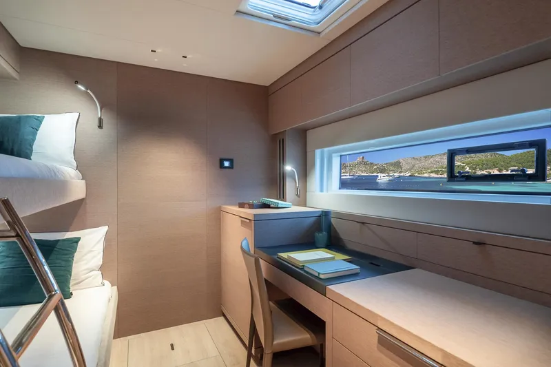 Slide: The Image of Luxurious cabin interior of 2025 Lagoon SIXTY 5 yacht with bunk beds and desk. - 43
