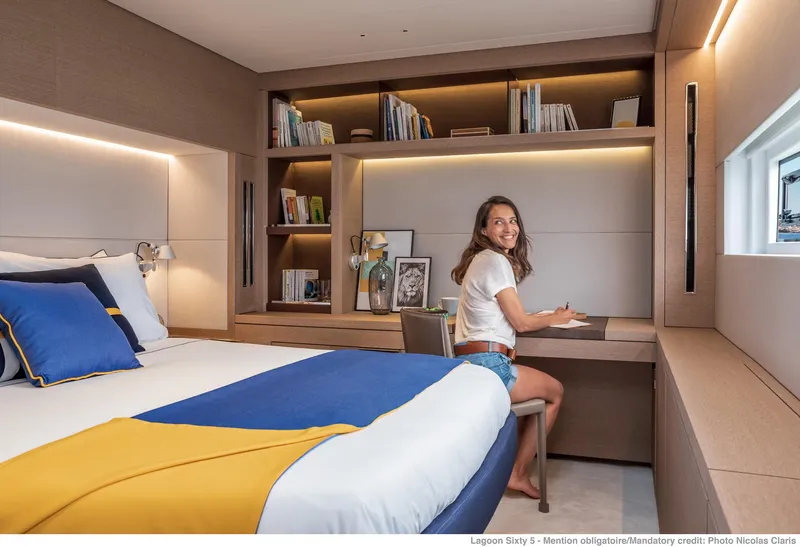 Slide: The Image of Modern cabin interior of 2025 Lagoon SIXTY 5 yacht with woman at desk. - 46