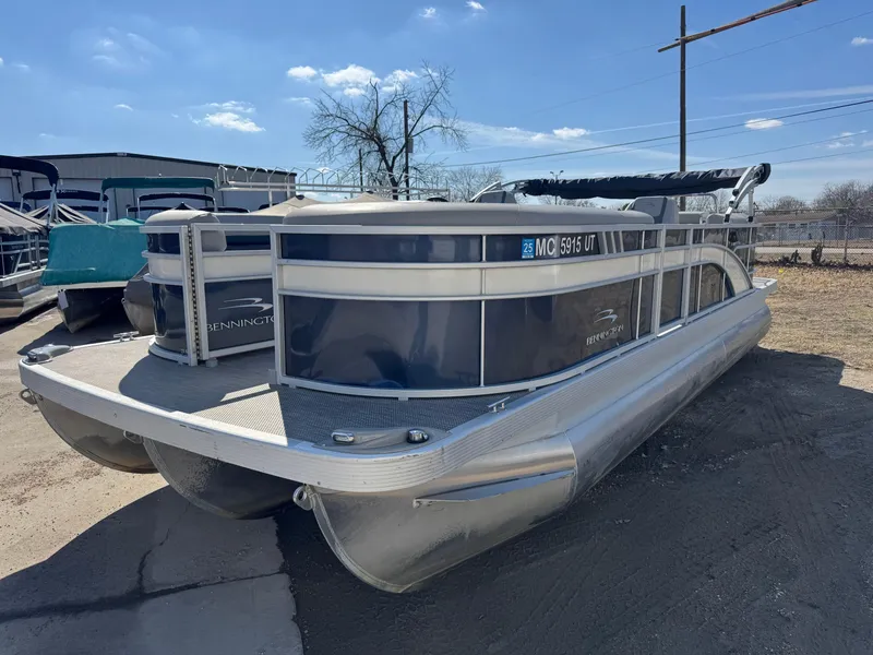 Slide: The Image of 2022 Bennington 23 SXSR pontoon boat parked outdoors on a sunny day. - 0