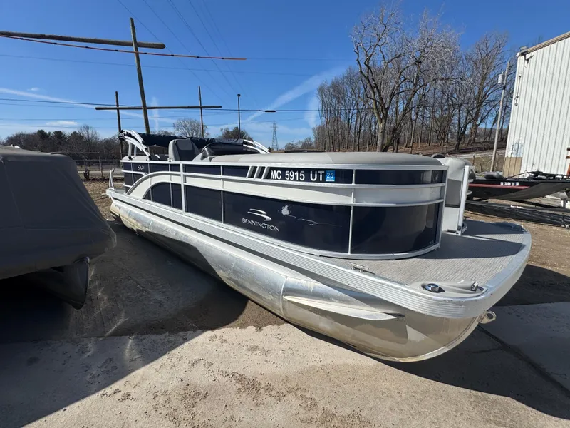 Slide: The Image of 2022 Bennington 23 SXSR pontoon boat parked outdoors on a sunny day. - 1