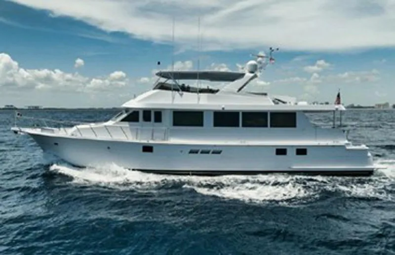 Slide: The Image of 1998 Hatteras 74 Cockpit Motor Yacht cruising on open water under a clear sky. - 2