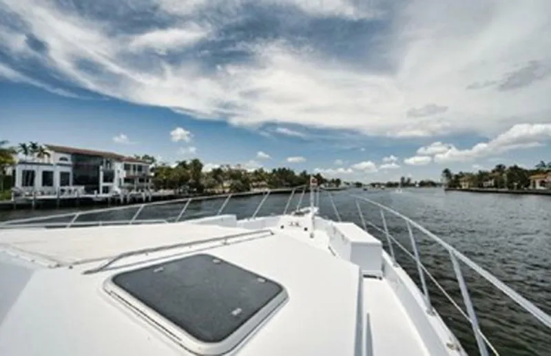 Slide: The Image of 1998 Hatteras 74 Cockpit Motor Yacht cruising on a scenic waterway. - 41