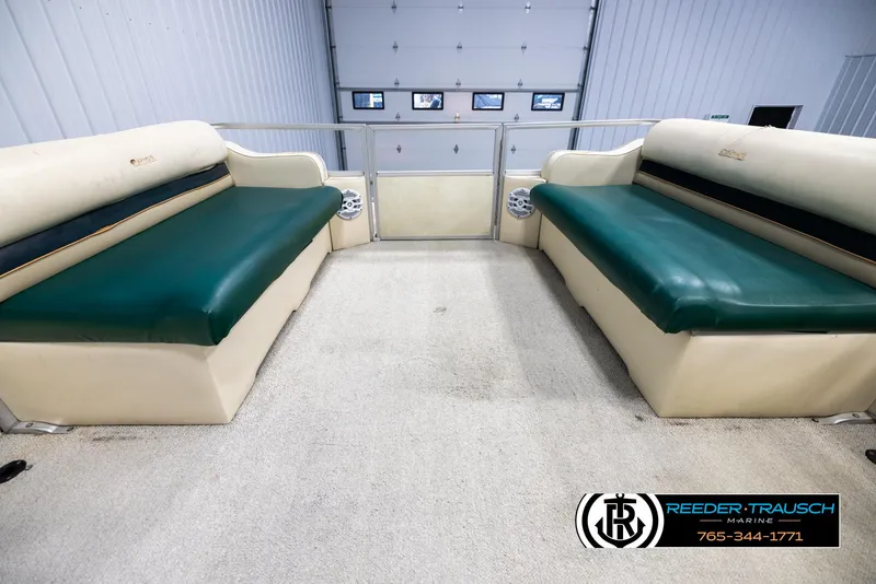 Slide: The Image of 1998 Crest 22 DLX boat interior with green and beige seating, spacious layout. - 18