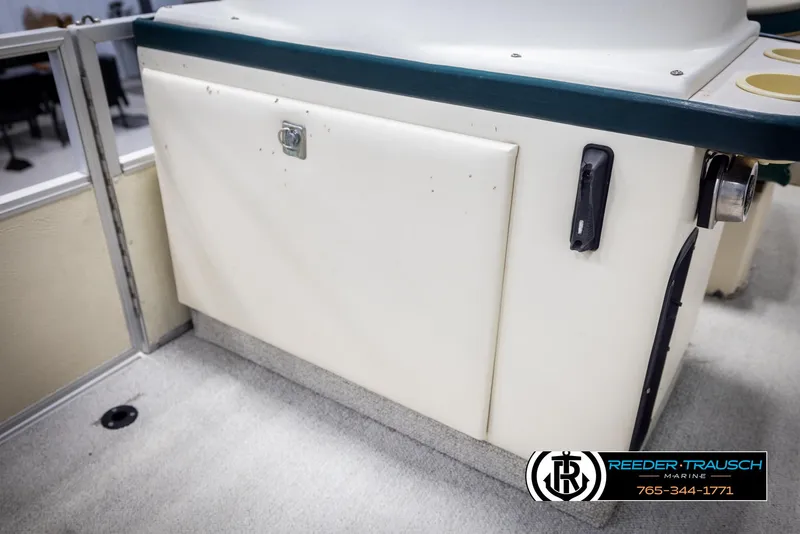 Slide: The Image of 1998 Crest 22 DLX boat interior detail with storage compartment and logo. - 20