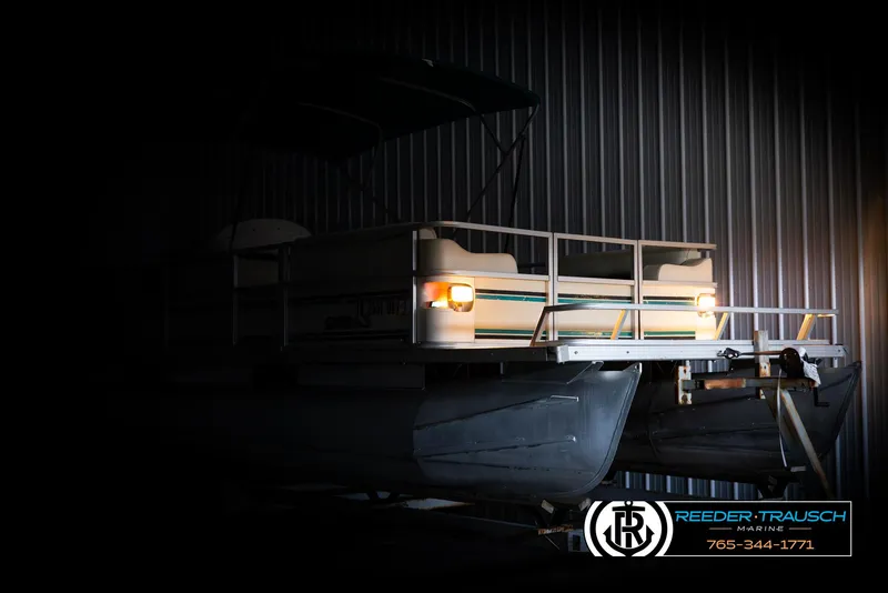 Slide: The Image of 1998 Crest 22 DLX pontoon boat in dimly lit storage facility. - 4