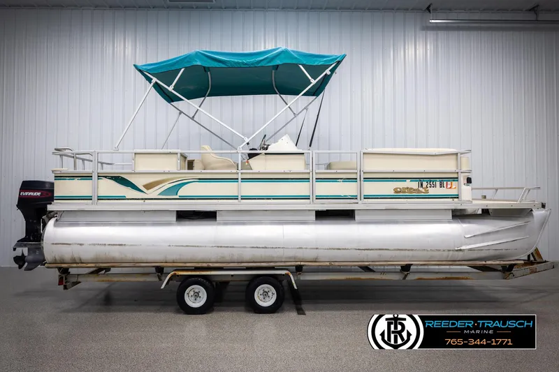 Slide: The Image of 1998 Crest 22 DLX pontoon boat with teal canopy on trailer in indoor setting. - 5
