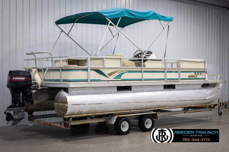 Slide: The Image of 1998 Crest 22 DLX pontoon boat with teal canopy on trailer, Evinrude motor attached. - 6