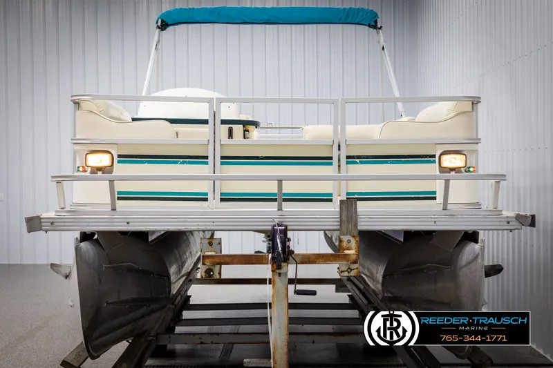 Slide: The Image of 1998 Crest 22 DLX pontoon boat with blue canopy in storage facility. - 8
