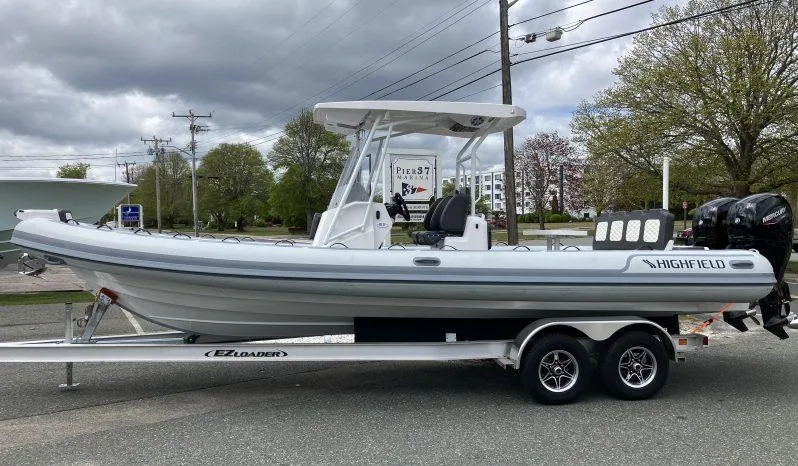 The Image of 2025 Highfield Sport 800 boat on trailer, parked outdoors under cloudy sky. - 0