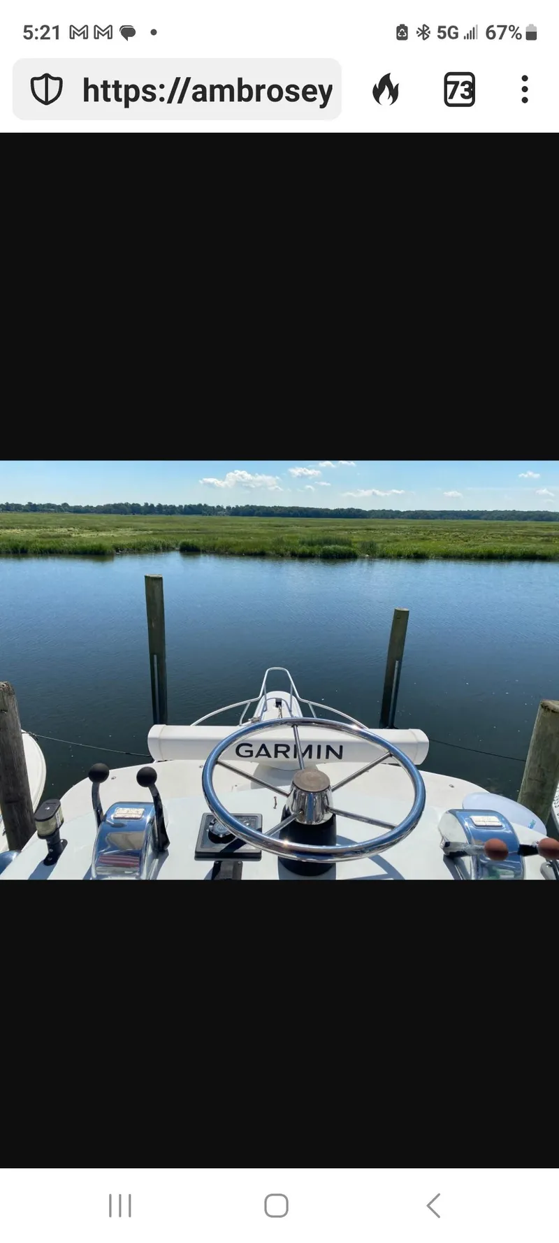 Slide: The Image of Dawson Yachts 33 EXPRESS 2000 steering wheel with Garmin system, docked by serene waters. - 25