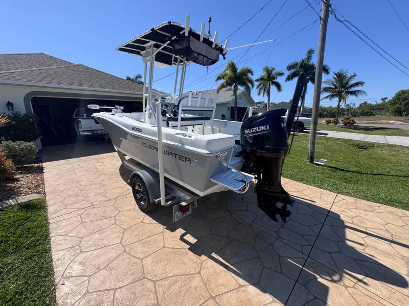 Slide: The Image of Clearwater 2000 C/C 2021 boat with 140 HP engine, docked under cloudy sky. - 4