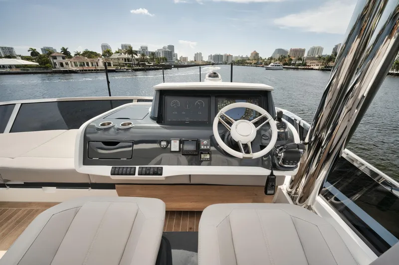 Slide: The Image of 2022 Pearl 62 yacht helm with modern controls and waterfront cityscape view. - 29