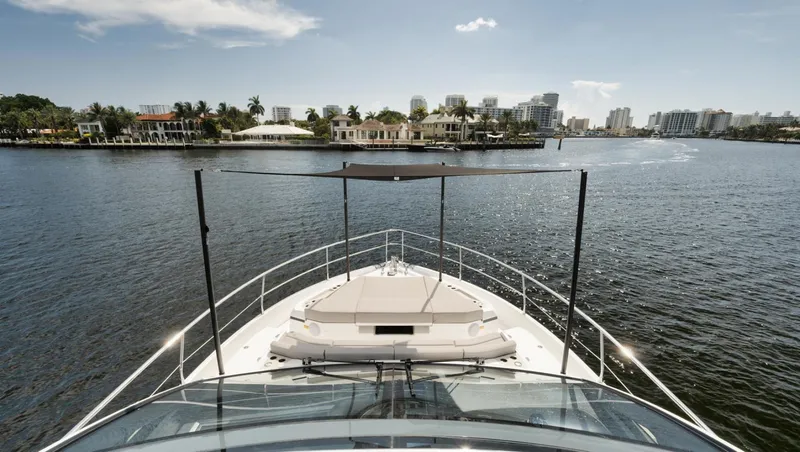 Slide: The Image of Pearl 62 yacht cruising on a sunny day, 2022 model, with waterfront cityscape. - 30