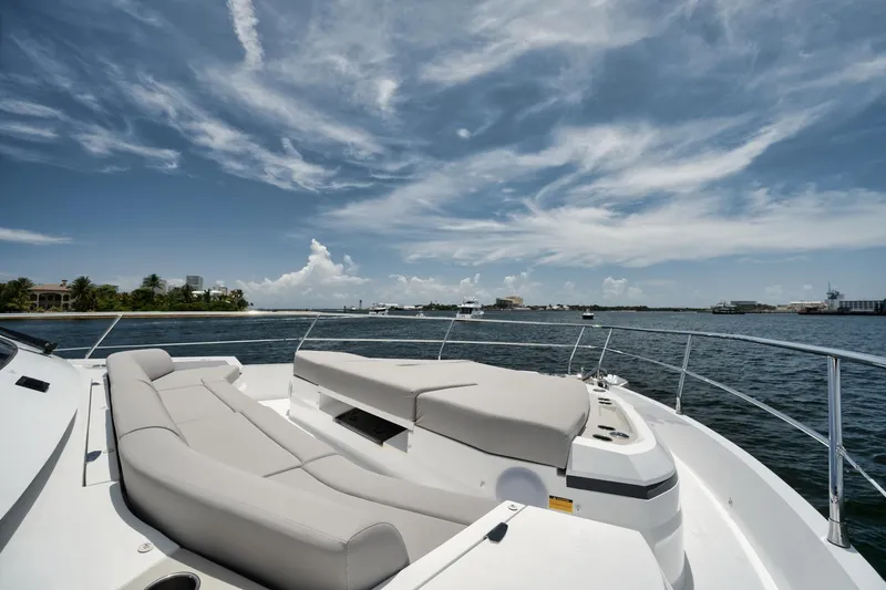Slide: The Image of Luxurious Pearl 62 yacht deck with plush seating, overlooking serene waters and a clear sky. - 44