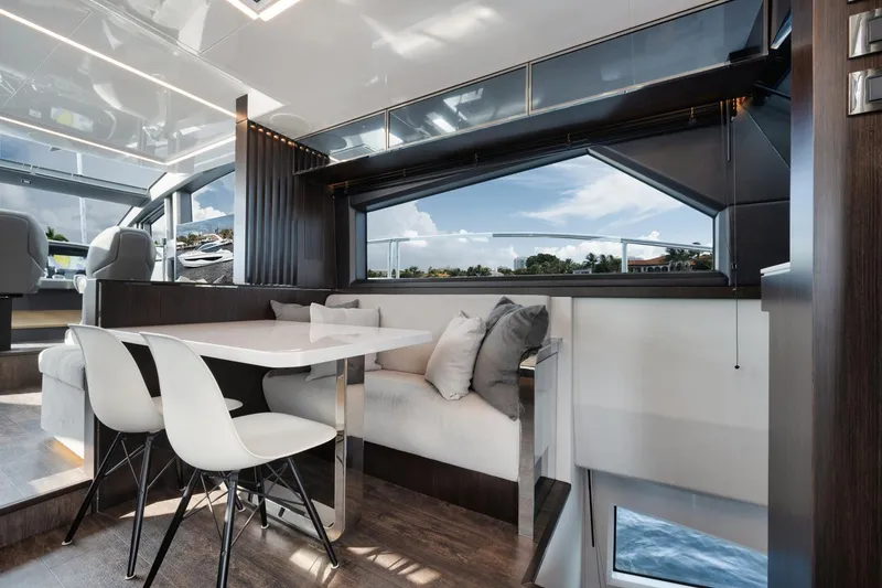 Slide: The Image of Luxurious interior of 2022 Pearl 62 yacht with modern dining area and scenic window view. - 9