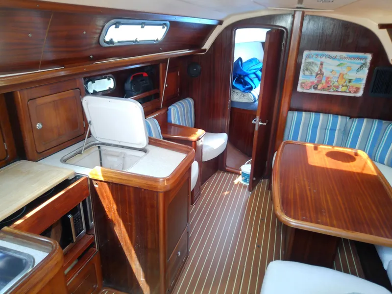 Slide: The Image of Interior of 2001 Bavaria 37 Cruiser yacht with wooden finish and striped seating. - 23