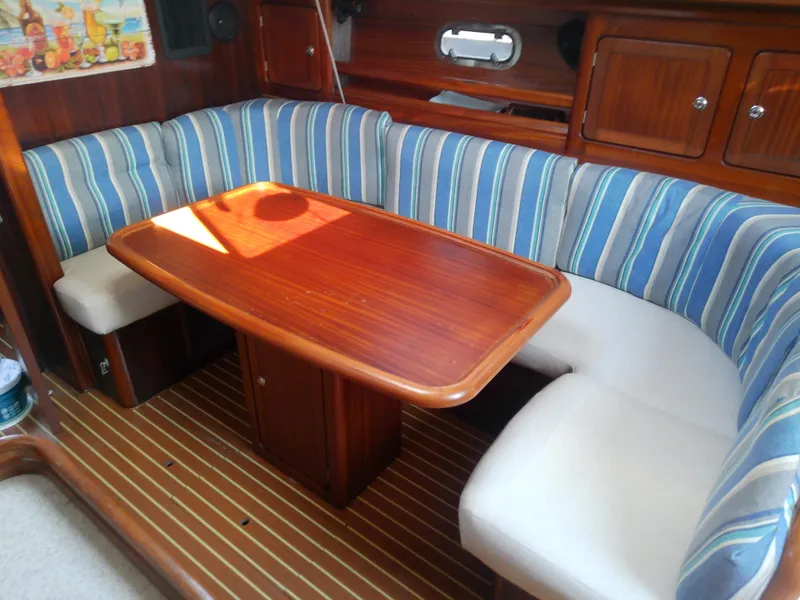 Slide: The Image of Interior of 2001 Bavaria 37 Cruiser with striped seating and wooden table. - 29