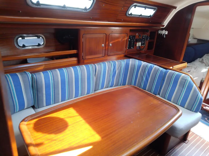 Slide: The Image of Interior of 2001 Bavaria 37 Cruiser with striped seating and wooden table. - 30