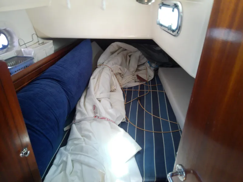 Slide: The Image of Interior cabin of 2001 Bavaria 37 Cruiser with blue cushions and nautical equipment. - 36