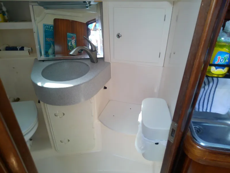 Slide: The Image of Interior of 2001 Bavaria 37 Cruiser bathroom with sink, mirror, and storage cabinets. - 40