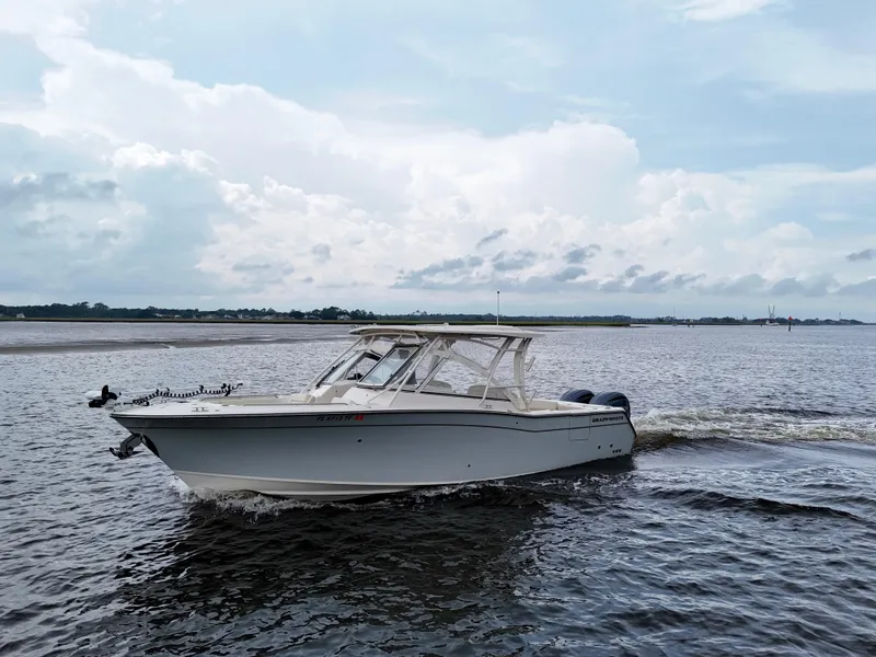 Slide: The Image of 2022 Grady-White Freedom 307 boat cruising on a calm, scenic waterway. - 13