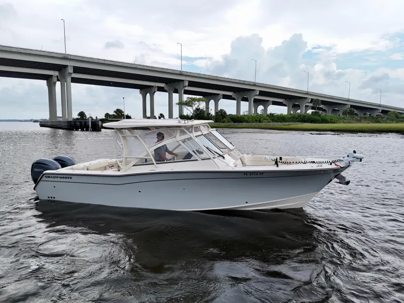 Slide: The Image of 2022 Grady-White Freedom 307 boat cruising under a bridge on a cloudy day. - 17