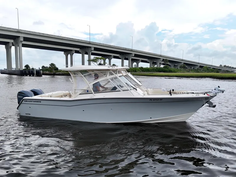 Slide: The Image of 2022 Grady-White Freedom 307 boat on water near a bridge, showcasing sleek design. - 18