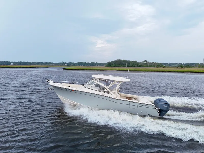 Slide: The Image of 2022 Grady-White Freedom 307 boat cruising on a calm river. - 2