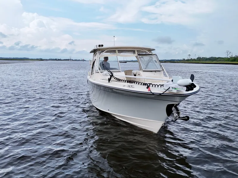 Slide: The Image of 2022 Grady-White Freedom 307 boat on calm water under a cloudy sky. - 21